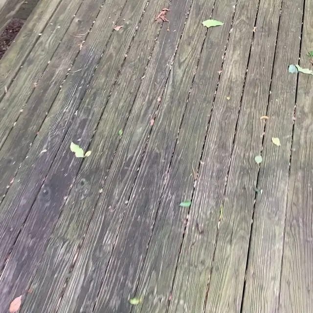 Close-up of weathered gray deck boards before restoration